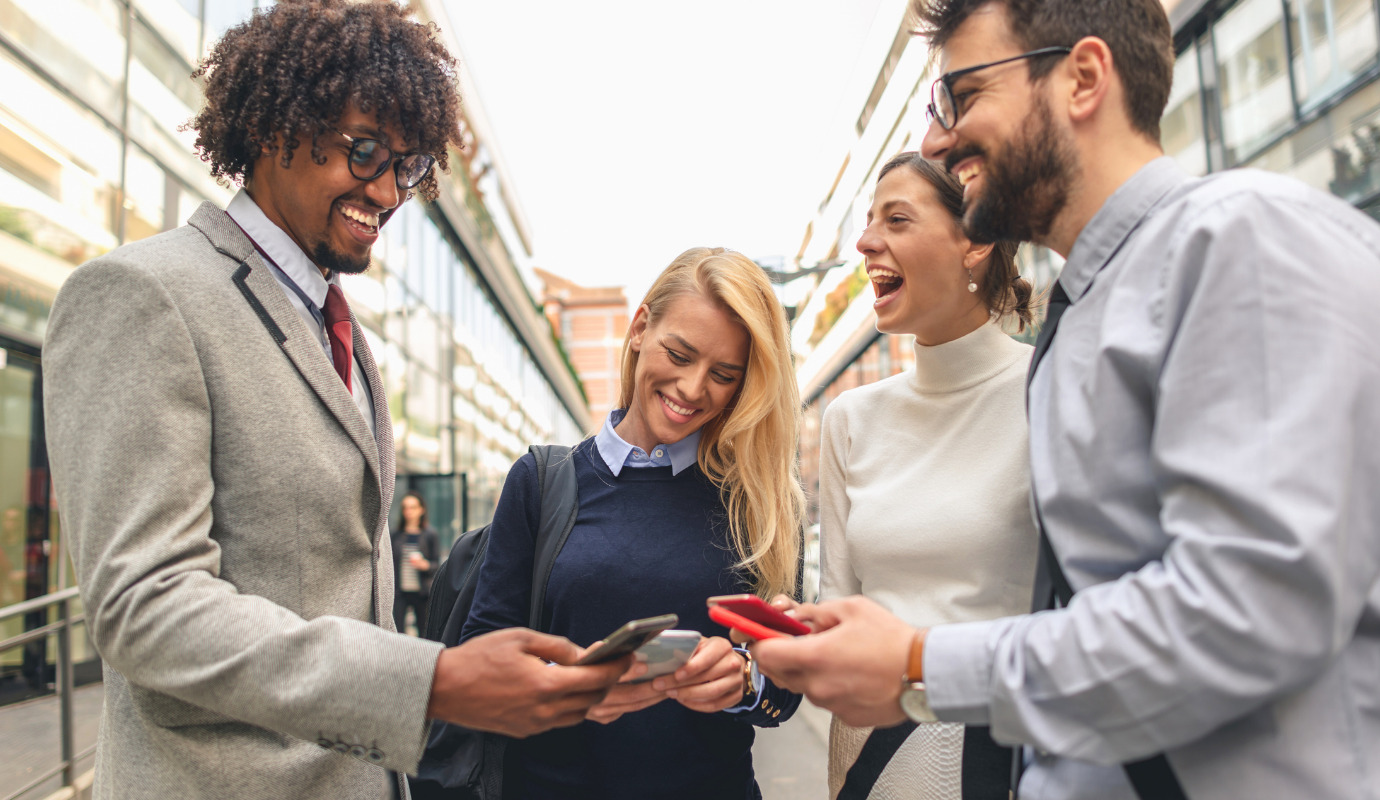 Group of people using smartphones to network outdoors.