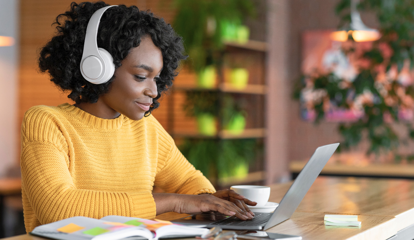Person doing an online training with headphones and laptop.